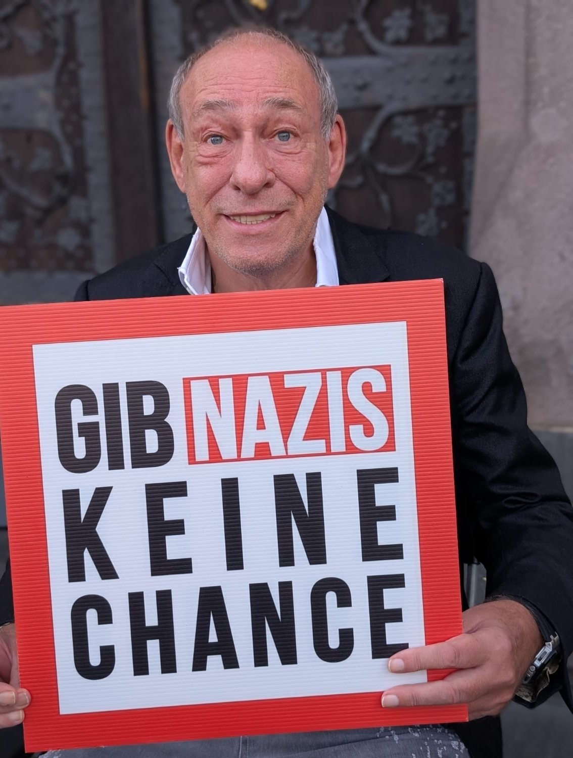 Peter Fischer hält ein Schild: Gib Nazis keine Chance